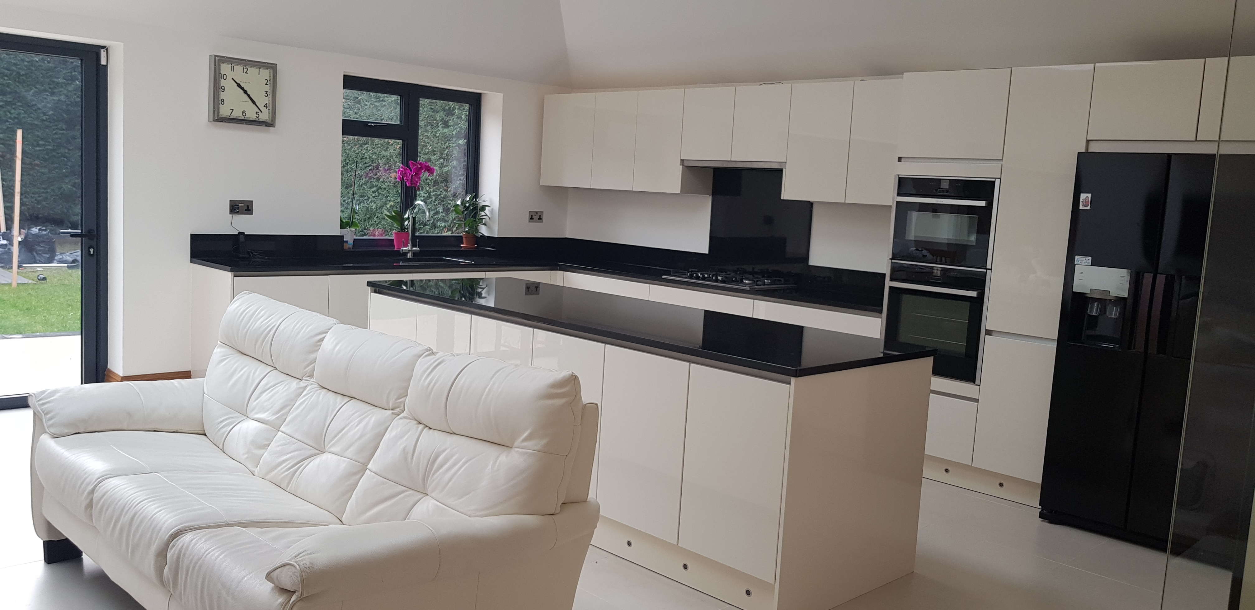 Open-plan kitchen with island and black granite worktop